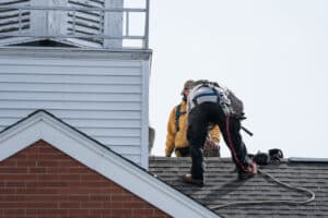 Two Male Roofer Installing A Roof